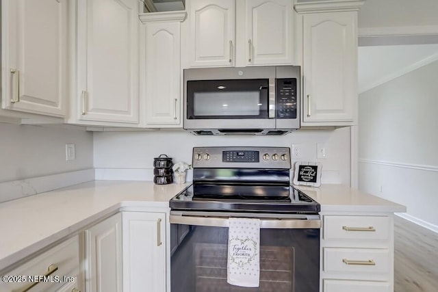 kitchen featuring light countertops, appliances with stainless steel finishes, and white cabinets