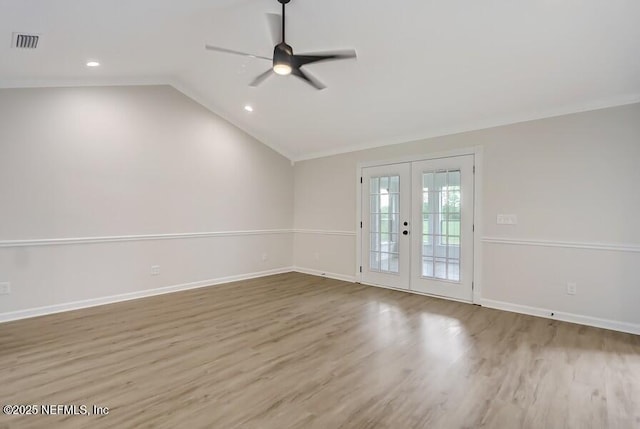 empty room featuring vaulted ceiling, french doors, ceiling fan, visible vents, and wood finished floors