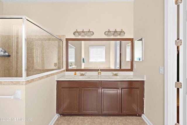 bathroom featuring double vanity, a sink, tile patterned floors, and tiled shower