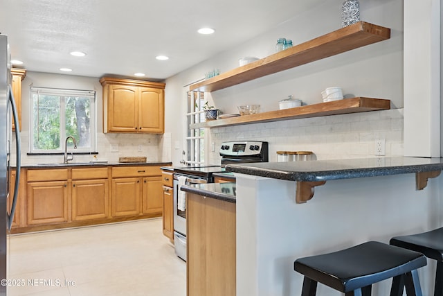 kitchen with a kitchen bar, open shelves, and appliances with stainless steel finishes