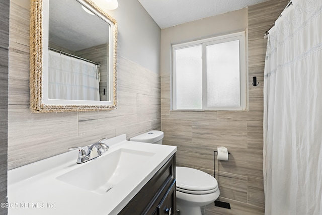 bathroom featuring tile walls, toilet, vanity, and a shower with curtain