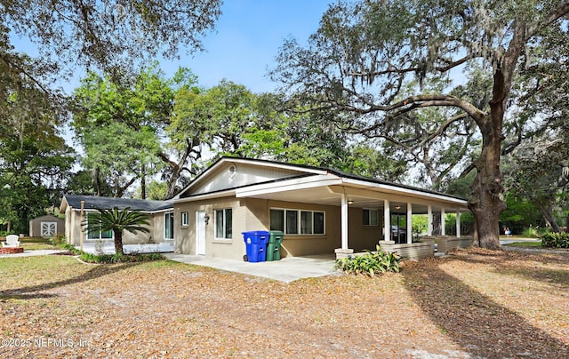 view of front of property with an outdoor structure, brick siding, and covered porch