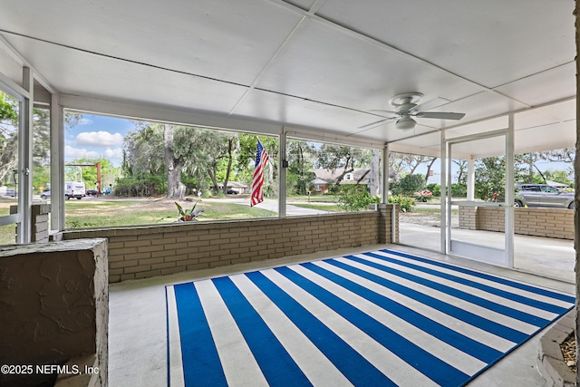 unfurnished sunroom featuring ceiling fan