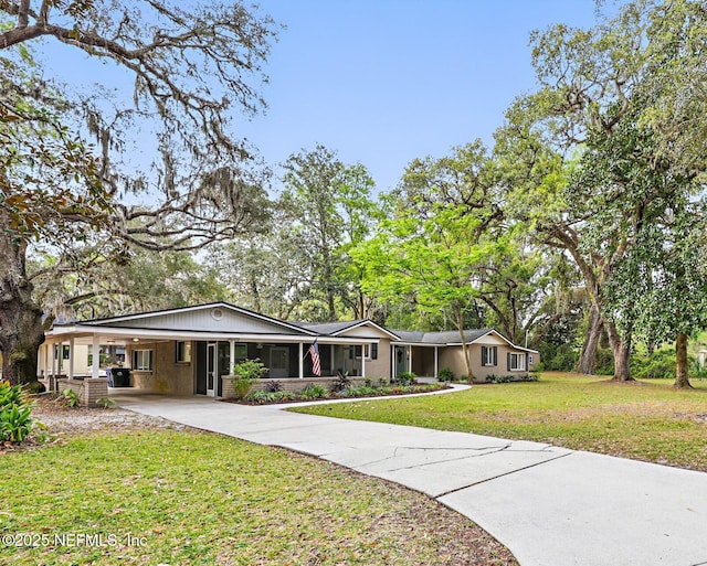 view of front facade with driveway, an attached carport, and a front yard