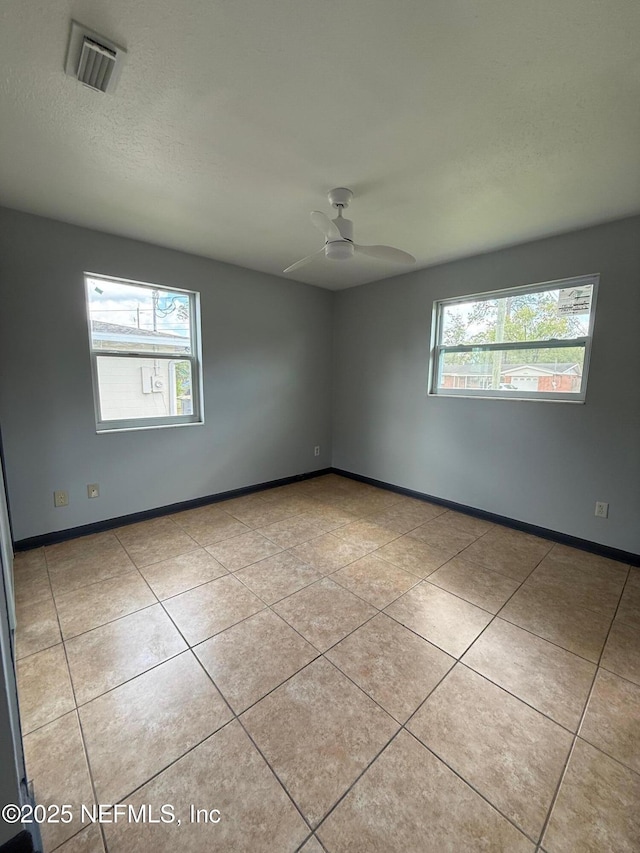 5521 Sabena Rd, Jacksonville, FL 32207 - empty room with tile patterned flooring, a ceiling fan, visible vents, and a healthy amount of sunlight