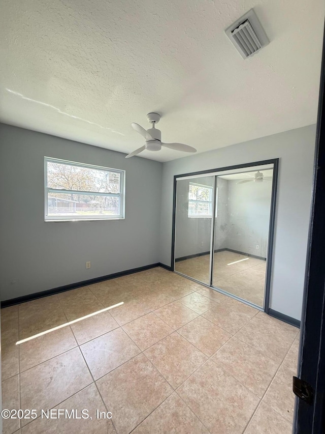 5521 Sabena Rd, Jacksonville, FL 32207 - unfurnished bedroom featuring tile patterned flooring, a textured ceiling, visible vents, and multiple windows