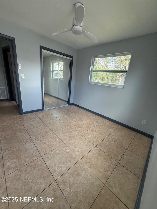 5521 Sabena Rd, Jacksonville, FL 32207 - unfurnished bedroom with tile patterned floors, baseboards, ceiling fan, and a closet