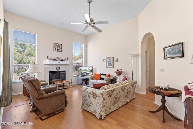 388 Lolly Ln, Saint Johns, FL 32259 - living room featuring arched walkways, light wood-type flooring, plenty of natural light, and a tile fireplace