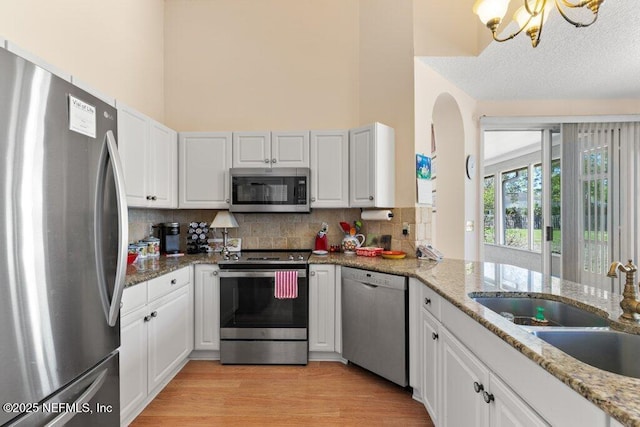 388 Lolly Ln, Saint Johns, FL 32259 - kitchen featuring a sink, backsplash, stainless steel appliances, and white cabinetry