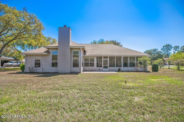 388 Lolly Ln, Saint Johns, FL 32259 - rear view of property featuring a lawn, a chimney, a sunroom, and a shingled roof
