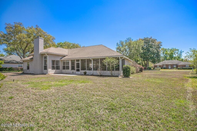 388 Lolly Ln, Saint Johns, FL 32259 - rear view of house featuring a sunroom, a lawn, stucco siding, and a chimney