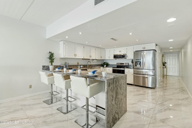 2280 Shepard St Unit 603, Jacksonville, FL 32211 - kitchen with white cabinets, marble finish floor, a peninsula, and stainless steel appliances