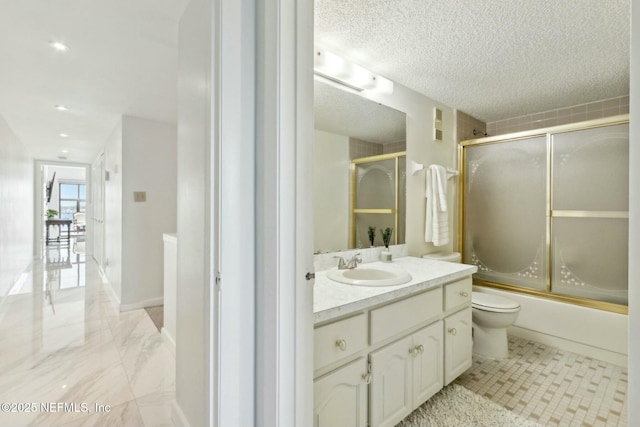 2280 Shepard St Unit 603, Jacksonville, FL 32211 - bathroom featuring combined bath / shower with glass door, a textured ceiling, toilet, and vanity