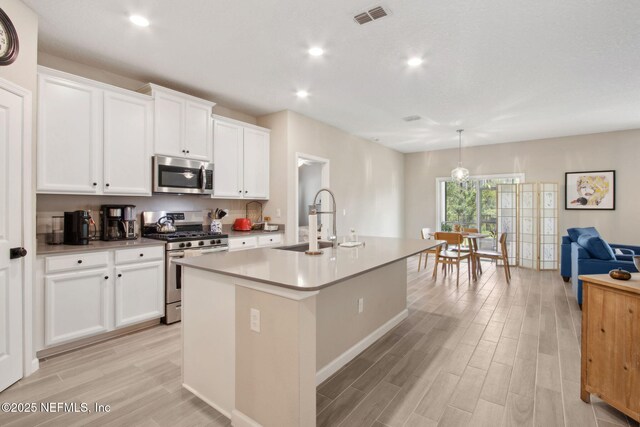 281 Tintamarre Dr, Saint Augustine, FL 32092 - kitchen featuring a sink, an island with sink, light wood finished floors, visible vents, and appliances with stainless steel finishes