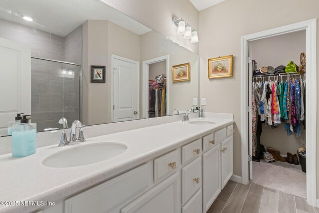 281 Tintamarre Dr, Saint Augustine, FL 32092 - bathroom with double vanity, a sink, a stall shower, and a walk in closet