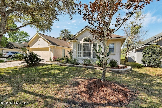 single story home with a front yard, stucco siding, an attached garage, and driveway