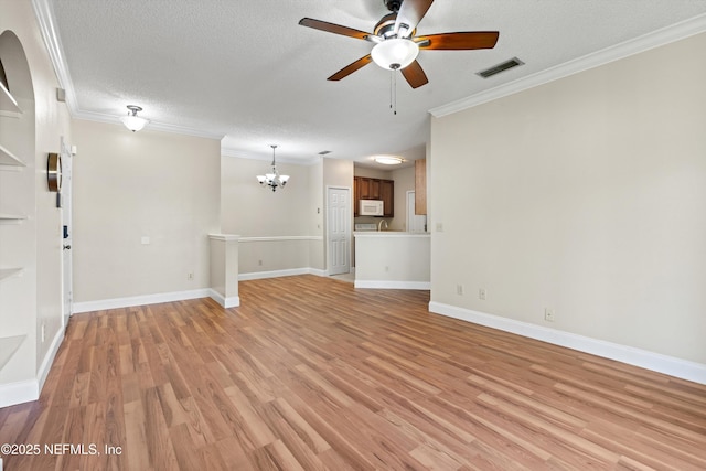 unfurnished living room featuring ornamental molding, ceiling fan with notable chandelier, a textured ceiling, light wood finished floors, and visible vents