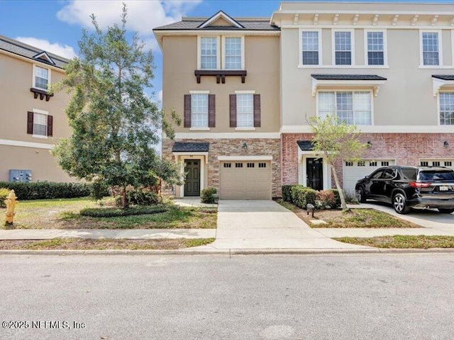4442 Capital Dome Dr, Jacksonville, FL 32246 - townhome / multi-family property featuring driveway, stucco siding, a garage, and stone siding