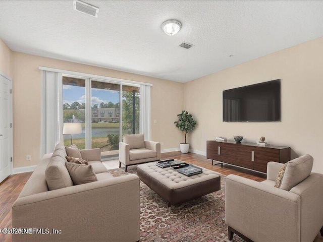 4442 Capital Dome Dr, Jacksonville, FL 32246 - living room featuring baseboards, visible vents, a textured ceiling, and wood finished floors