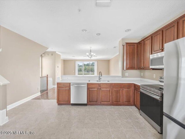 4442 Capital Dome Dr, Jacksonville, FL 32246 - kitchen featuring light countertops, stainless steel appliances, a sink, a notable chandelier, and brown cabinetry
