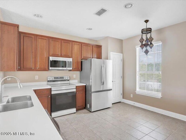 4442 Capital Dome Dr, Jacksonville, FL 32246 - kitchen with light countertops, a sink, visible vents, appliances with stainless steel finishes, and brown cabinetry