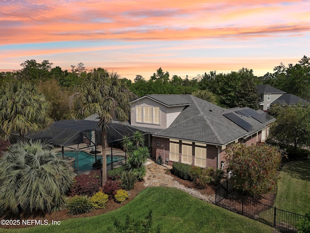 553 S Bridge Creek Dr, Saint Johns, FL 32259 - rear view of property featuring fence, glass enclosure, a fenced in pool, roof with shingles, and a lawn
