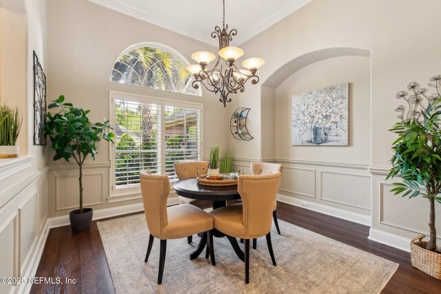 553 S Bridge Creek Dr, Saint Johns, FL 32259 - dining area with a notable chandelier, crown molding, a decorative wall, and dark wood-style flooring