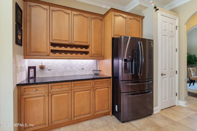 553 S Bridge Creek Dr, Saint Johns, FL 32259 - kitchen with crown molding, refrigerator with ice dispenser, backsplash, dark stone countertops, and arched walkways