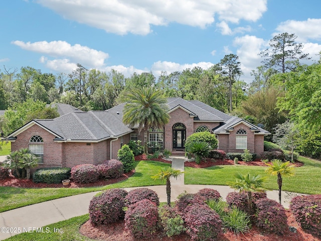 553 S Bridge Creek Dr, Saint Johns, FL 32259 - view of front of home with brick siding, a front yard, and a shingled roof