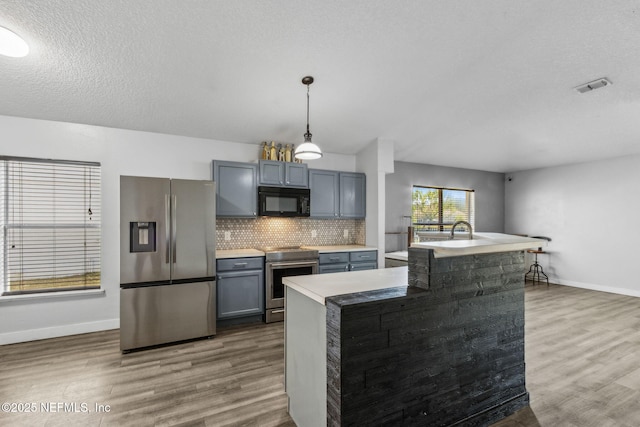 kitchen with dark wood finished floors, visible vents, backsplash, and stainless steel appliances