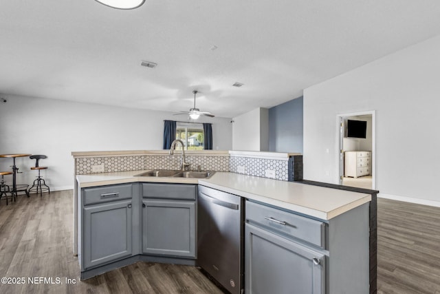 kitchen featuring dishwasher, a sink, gray cabinetry, and ceiling fan