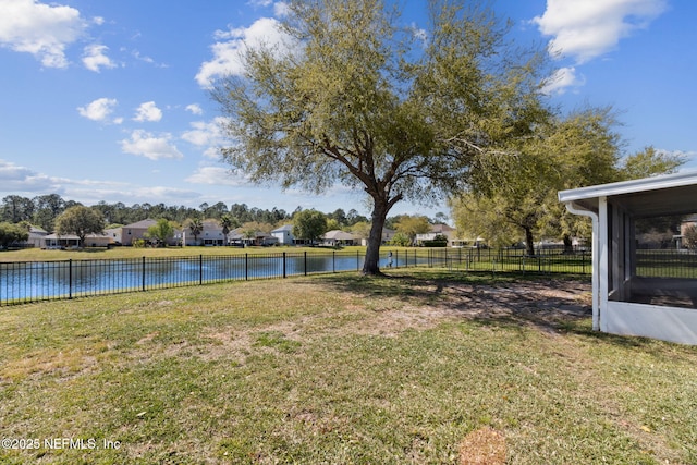 view of yard featuring a water view, fence, and a residential view