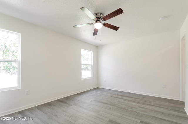 5755 Teeler Ave, Jacksonville, FL 32208 - empty room featuring wood finished floors, ceiling fan, baseboards, and a textured ceiling