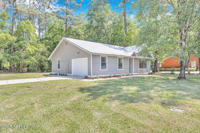 view of front of house featuring a garage, a front yard, metal roof, and driveway