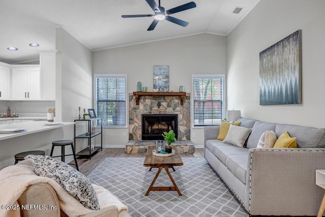 living area featuring a wealth of natural light, light wood-style floors, visible vents, and lofted ceiling