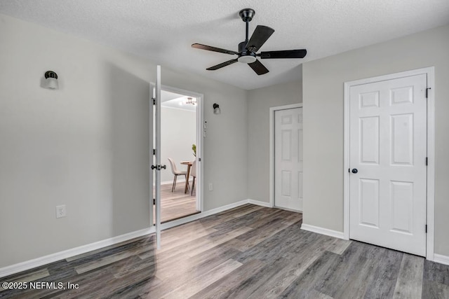 unfurnished bedroom with baseboards, ceiling fan, wood finished floors, and a textured ceiling