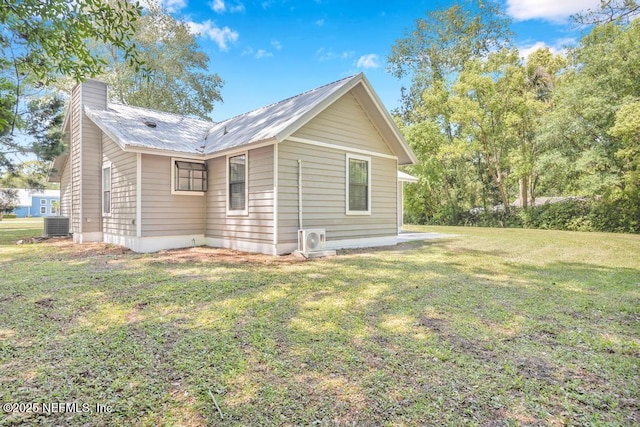 view of property exterior with ac unit, metal roof, a lawn, a chimney, and cooling unit
