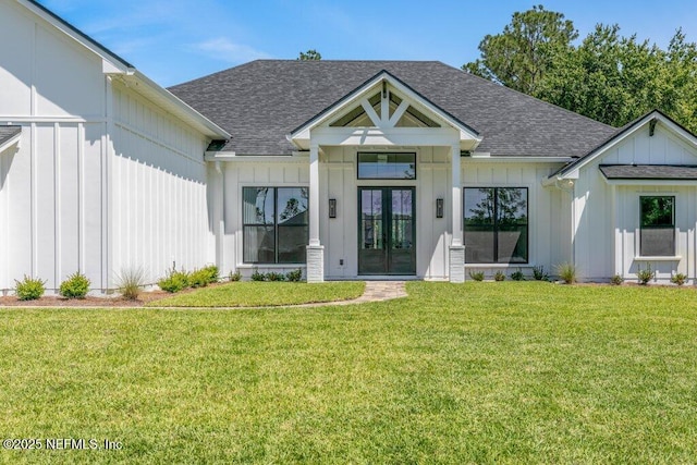 9921 Derby Gate Ct, Jacksonville, FL 32219 - view of front facade with french doors, board and batten siding, a shingled roof, and a front lawn
