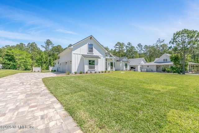 9921 Derby Gate Ct, Jacksonville, FL 32219 - modern farmhouse with decorative driveway, a front yard, board and batten siding, and an attached garage