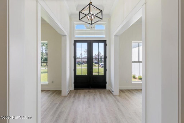 9921 Derby Gate Ct, Jacksonville, FL 32219 - entryway with french doors, a chandelier, light wood-style flooring, and baseboards