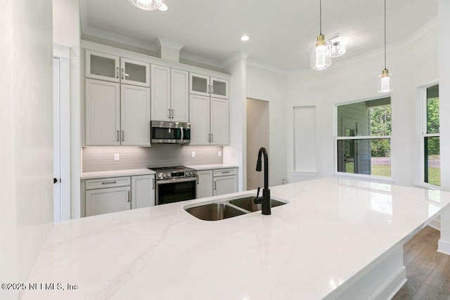9921 Derby Gate Ct, Jacksonville, FL 32219 - kitchen featuring stainless steel appliances, a sink, crown molding, decorative backsplash, and light stone countertops