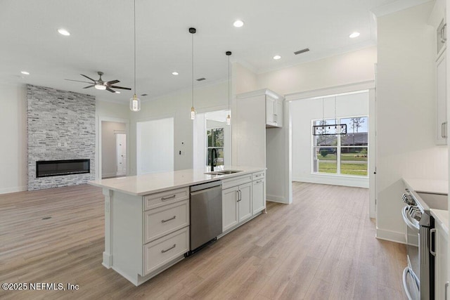 9921 Derby Gate Ct, Jacksonville, FL 32219 - kitchen featuring stainless steel appliances, a sink, a ceiling fan, white cabinets, and light countertops