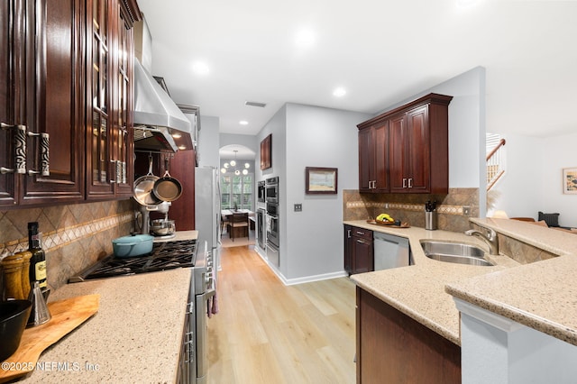 424 High Tide Dr, Saint Augustine, FL 32080 - kitchen featuring visible vents, wall chimney exhaust hood, a sink, appliances with stainless steel finishes, and light stone countertops