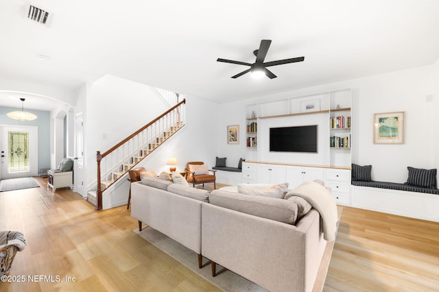 424 High Tide Dr, Saint Augustine, FL 32080 - living room featuring arched walkways, stairs, light wood-style floors, and a ceiling fan