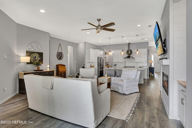 559 Willow Lake Dr, Saint Augustine, FL 32092 - living room featuring a large fireplace, ceiling fan, recessed lighting, stairway, and dark wood-type flooring