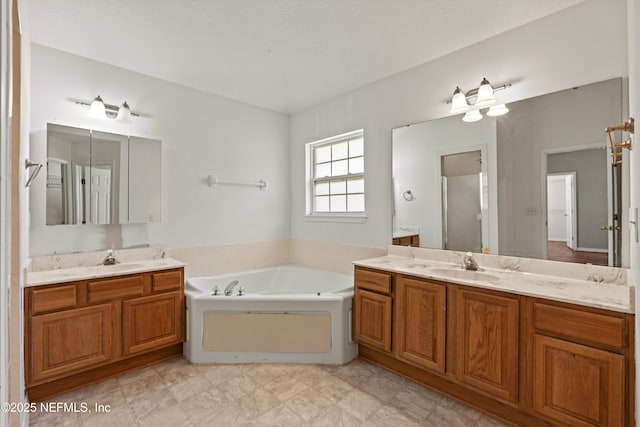bathroom with a sink, two vanities, and a bath