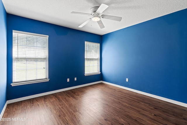 empty room featuring a textured ceiling, baseboards, ceiling fan, and wood finished floors