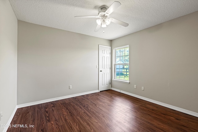 spare room with dark wood-type flooring, baseboards, a textured ceiling, and ceiling fan