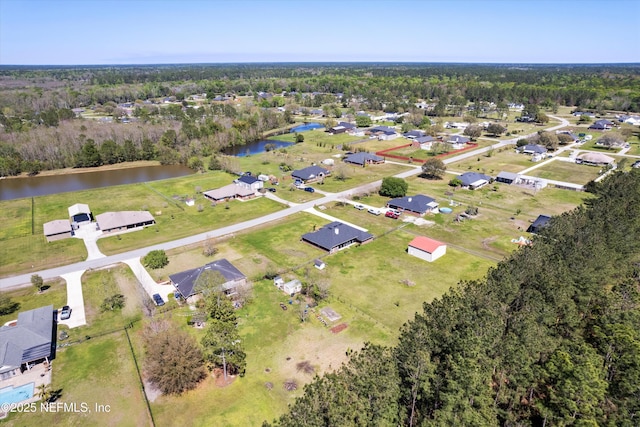 birds eye view of property featuring a water view and a view of trees