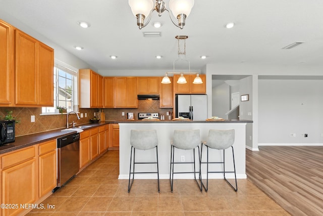 210 Crown Wheel Cir, Saint Johns, FL 32259 - kitchen with appliances with stainless steel finishes, a breakfast bar, a center island, decorative backsplash, and dark countertops